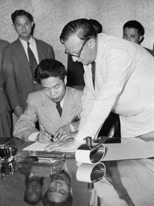 Orig. caption ... MENDES-FRANCE WINS INDO-CHINA AGREEMENT. 95-minutes after his self-imposed dead-line, won agreement with the communists to halt the Indo-China war. Before midnight he had already reached agreement on the future of Vietnam and Laos but it was not until after midnight that the future of Cambodia could be settled. Photo shows: Colonel Ta Quang, Vietminh defense minister signs the armistice agreement in Geneva early today. Beside him is M. Jean Paul Boncourt. Note Indochina - name of former French Indochina extensively now: Cambodia, Laos and Vietnam. The Indochina War broke out in 1946 and was waged by Vietnamese forces against the French army. The war ended in 1954 at a conference in Geneva. In addition to the ceasefire, the  Copyright: xXxXxXx SIGNATURE OF ARMED STATE