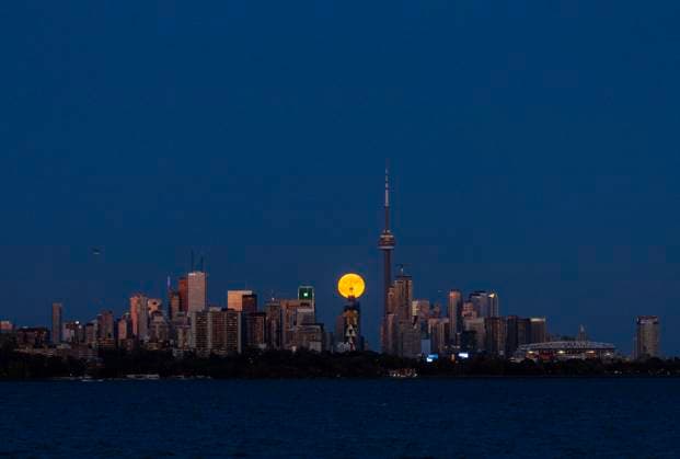 (241018) -- TORONTO, Oct. 18, 2024 -- The full moon rises over the skyline in Toronto, Canada, on Oct. 17, 2024. (Photo by Xinhua) CANADA-TORONTO-FULL MOON ZouxZheng 