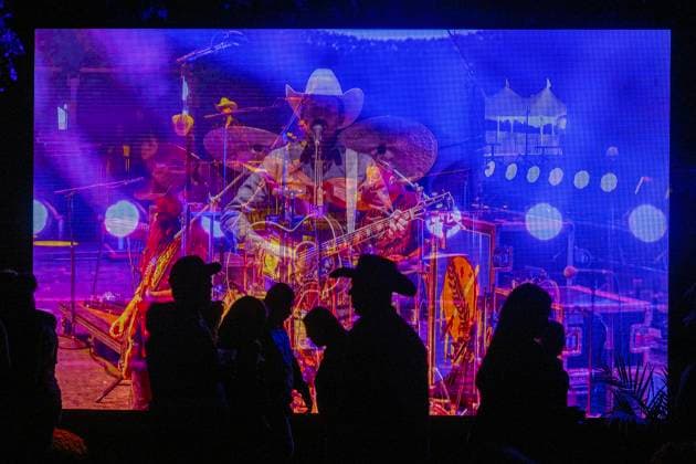October 18, 2024, Sacramento, Ca, USA: Fans walk past TV monitors with Turnpike Trobadors preforming during the Golden Sky Music Festival at Discovery Park on Friday, Oct. 18, 2024 in Sacramento. Sacramento USA - ZUMAj89_ 20241018_zaf_j89_022 Copyright: xPaulxKitagakixJr.x
