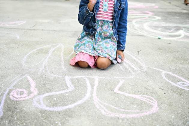 Creative Highlights Symbolfotos Child kneeling on pavement, holding chalk, large chalk drawing b United States, Florida, Inverness R_YWQX241022-1567301-01 ,model released, Symbolfoto