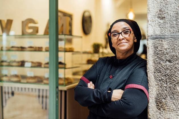 Creative Highlights Symbolfotos Smiling woman, standing confidently in her vegan bakery with donuts visible in the background, represents success and health-conscious entrepreneurship Model Released AlexSalcedo_ID24687_715173_005 Copyright: xAlexxSalcedox RECORD DATE NOT STATED