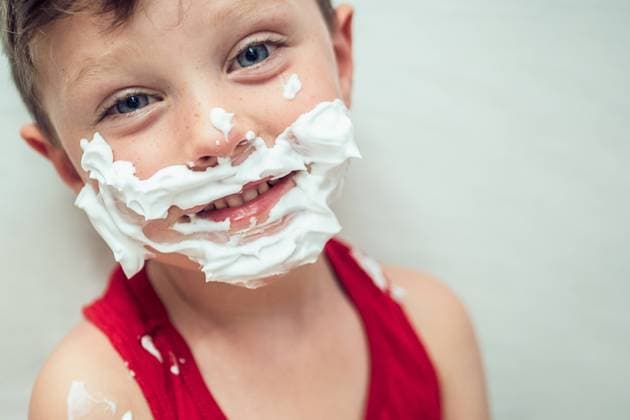 Creative Highlights Symbolfotos Young boy with blue eyes and shaving foam on his face simulates shaving, wearing a red tank top, looking directly at the camera. Model Released HodeiUnzueta_ID24402_707402_004 Copyright: xHodeixUnzuetax RECORD DATE NOT STATED