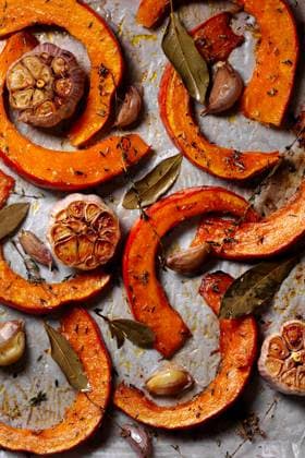Top view of freshly baked pumpkin slices seasoned with garlic, bay leaves, and thyme on a baking sheet. Perfect for a homemade autumn dish. Model Released JuliaKuvaldina_ID24568_712095_003 Copyright: xJuliaxKuvaldinax