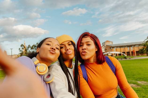 Creative Highlights Symbolfotos Three black Latin American girls capture a vibrant selfie on a lively college campus, showcasing their friendship and diverse styles against a backdrop of greenery and architecture Model Released AlbertoMenendez_ID15110_461105_036 Copyright: xx RECORD DATE NOT STATED