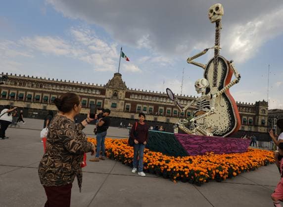 Mega Ofrenda For Dia de Muertos Celebrations A person taking photos of the Mega Ofrenda featuring monumental cardboard skeletons at the main square Zocalo as part of the Mexican Dia de Muertos festivities. on October 31, 2024 in Mexico City, Mexico. (Photo by Ian Robles Eyepix Group) Copyright: xIanxRobles xEyepixxGroupx EL_31102024_134237JPEG