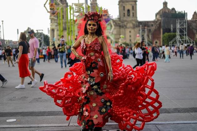 A woman wears a red balloons dress and her face painted as skull attends the Mega Ofrenda featuring monumental cardboard skeletons at the main square Zocalo as part of the Mexican Dia de Muertos festivities. on October 31, 2024 in Mexico City, Mexico. Mexico City Mexico - ZUMAe321 20241031_zia_e321_070 Copyright: xIanxRoblesx