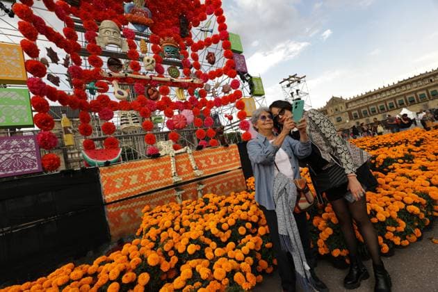 Two women taking selfies in front the Mega Ofrenda featuring monumental cardboard skeletons at the main square Zocalo as part of the Mexican Dia de Muertos festivities. on October 31, 2024 in Mexico City, Mexico. Mexico City Mexico - ZUMAe321 20241031_zia_e321_064 Copyright: xIanxRoblesx