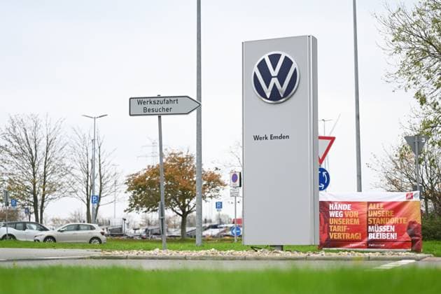 Volkswagen-Werk Emden in der Krise. Vor dem Volkswagen-Werk Emden steht ein Schild mit der Aufschrift Werk Emden. Daneben stehen Banner der IG-Metall Küste. Europas größter Autobauer möchte drei Werke in Deutschland schließen und Zehntausende Mitarbeiter entlassen. Emden Niedersachsen Deutschland *** Volkswagen Emden plant in crisis A sign in front of the Volkswagen Emden plant reads Emden plant Next to it are banners from IG Metall Küste Europes largest carmaker wants to close three plants in Germany and lay off tens of thousands of employees Emden Lower Saxony Germany Copyright: xdiebildwerftx