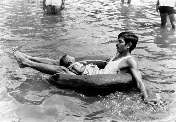 Man floating on water with his baby, India Copyright: xTxSatyan DinodiaxPhotox