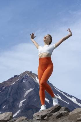 Creative Highlights Symbolfotos Yoga Lehrerin ist eine schlanke, fitte Frau in T Shirt, orangefarbener Yogahose und Turnschuhen vor dem Hintergrund eines Vulkans. Sportler in Entspannungshaltung mit erhobenen und ausgestreckten Armen, Augen geschlossen Yoga instructor is fit woman of slim build, wearing T-shirt, orange yoga pants and trainers, against background of volcano. Athlete in relaxation poses with arms raised and outstretched, eyes closed Copyright: imageBROKER AlexanderxA.xPiragis ibxiqx11670615.jpg ,model released, Symbolfoto ,property released