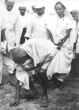 Mahatma Gandhi breaking salt law by picking up lump of natural salt at Dandi, Gujarat, India, April 6, 1930, 8.30 a.m. - MODEL RELEASE NOT AVAILABLE Copyright: xVithalbhaixJhaveri DinodiaxPhotox