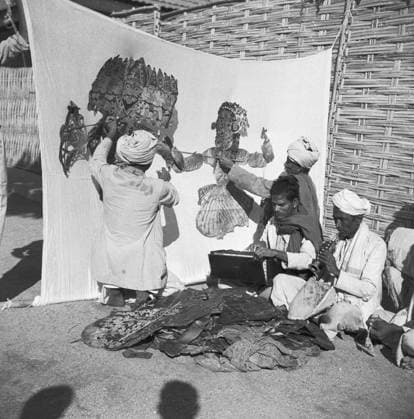 Men sitting behind cloth screen light thrown manipulate leather flat puppet shadow puppet play ; Hallare village ; Mysore Copyright: xTxSatyan DinodiaxPhotox