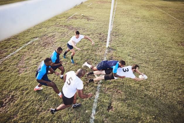 Rugby, team and diving with ball for touchdown or win score with a try, tackle and competitive sports or game. Above, athlete and field for football or running for championship tournament and match model released property released Copyright: xPeopleImages.comx-x 2514140x