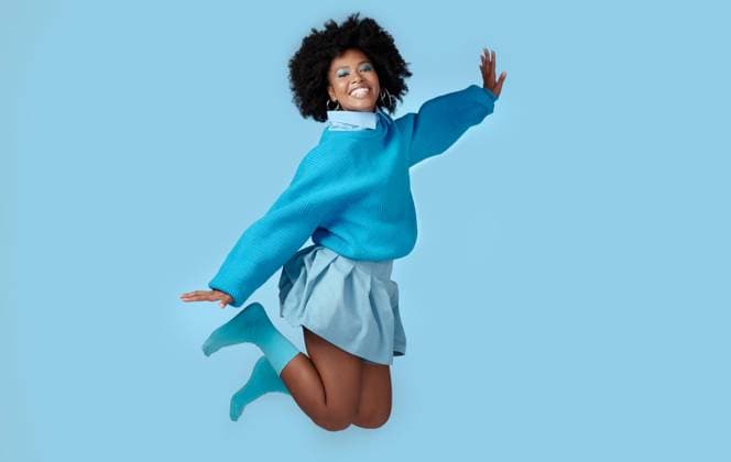 Creative Highlights Symbolfotos Blue, jump and happy black woman in a studio with trendy, cool and stylish clothes with a background. Happiness, smile and portrait of a young african model with energy, excited and joy model released property released Copyright: xwww.peopleimages.comx
