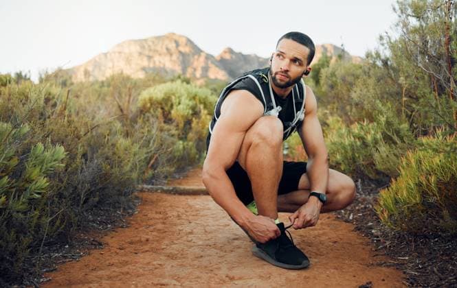 Creative Highlights Symbolfotos Fitness, nature and man tie shoes before start of marathon training, exercise or health workout in USA Hollywood Hills. Sports, dirt path and runner ready for peace, freedom or wellness cardio run. model released property released Copyright: xwww.peopleimages.comx