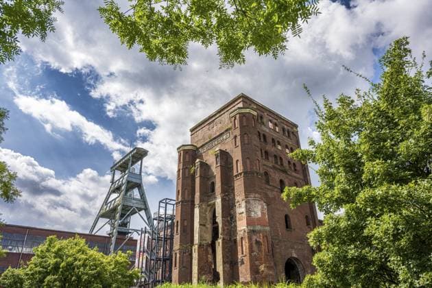 Alter Industriebau und Förderturm vor einem klaren Himmel, eingebettet in grüner Landschaft, Förderturm der Zeche Ewald in Herten Old industrial building and winding tower in front of a clear sky, embedded in a green landscape, winding tower of the Ewald colliery in Herten Copyright: imageBROKER MarkusxQuabach ibxmqu11716170.jpg