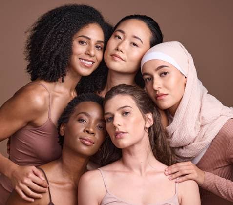 Diversity, beauty and portrait of a group of women in studio for skincare, makeup or cosmetic routine. Feminism, female empowerment and face of multicultural girl friends isolated by brown background. model released property released Copyright: xwww.peopleimages.comx