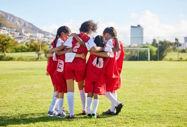 Diversity, sports girl hug and soccer field training for youth competition match playing at stadium grass. Team, young athlete or player enjoy football teamwork or support world cup championship. model released property released Copyright: xwww.peopleimages.comx