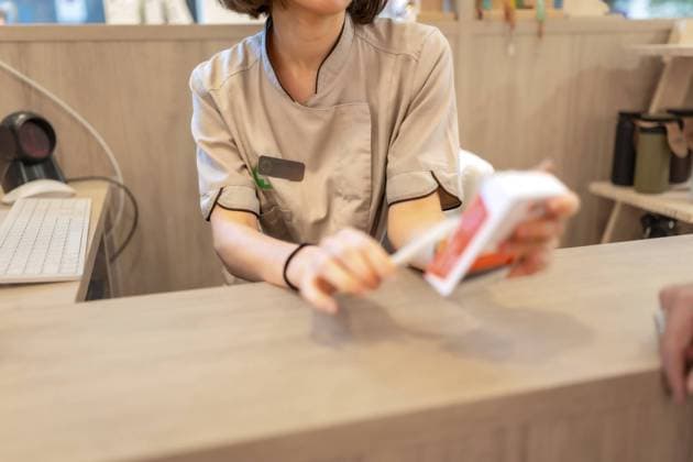 Ausgeschnittenes Foto eines Apothekers, der eine Packung mit Medikamenten hält und einen Kunden bedient Cropped photo of a pharmacist holding a package of medicine attending a client Copyright: imageBROKER UnaixHuizi ibxuhu11506495.jpg ,model released, Symbolfoto ,property released