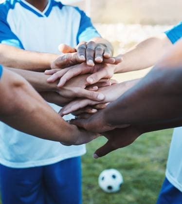 Hands stacked, sports and men on a soccer field for support, motivation and team spirit. Goal, training and athlete football players with a gesture for celebration, solidarity and trust at a game. model released property released Copyright: xwww.peopleimages.comx
