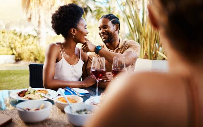 IMAGO Creative, Ostern, Bräuche, Osterbrunch Outdoor lunch, friends and happy black couple, woman and man wipe, cleaning and remove food from African girlfriend. Together, reunion and people bonding, smile and enjoy meal, buffet or brunch. model released property released Copyright: xPeopleImages.comx-x 2735613x