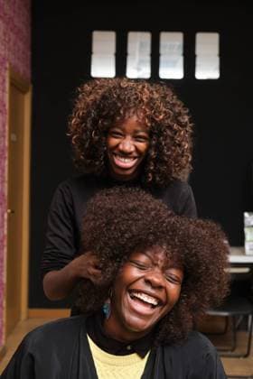 Creative Highlights Symbolbilder Hairdresser styling afro hair of laughing customer in salon Madrid, Community of Madrid, Spain CR_CRVI241102-1569709-01 ,model released, Symbolfoto ,property released