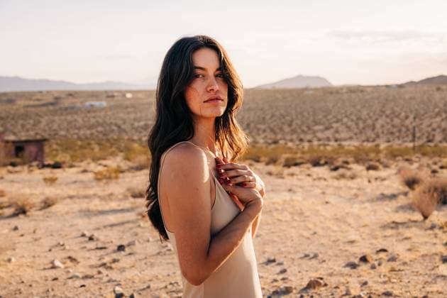 Creative Highlights Symbolbilder Woman in desert with hands on chest, gazing softly at camera Joshua Tree, California, United States CR_FKNH241101B-1575528-01 ,model released, Symbolfoto