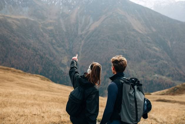 Two hikers pause, one pointing towards distant mountains Kals am Großglockner, Tyrol, Austria CR_MGTP241104-1575701-01 ,model released, Symbolfoto