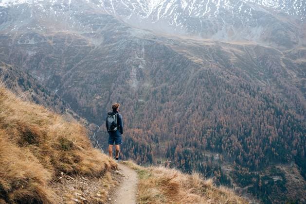 Creative Highlights Symbolbilder Solo hiker overlooking a vast, autumnal valley from a rugged trail Kals am Großglockner, Tyrol, Austria CR_MGTP241104-1575702-01 ,model released, Symbolfoto