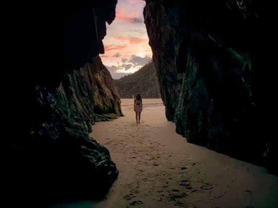 Creative Highlights Symbolbilder silhouette of woman in a cave on the beach with sunset Bilbao, Basque Country, Spain CR_NELA241112-1498038-01 ,model released, Symbolfoto