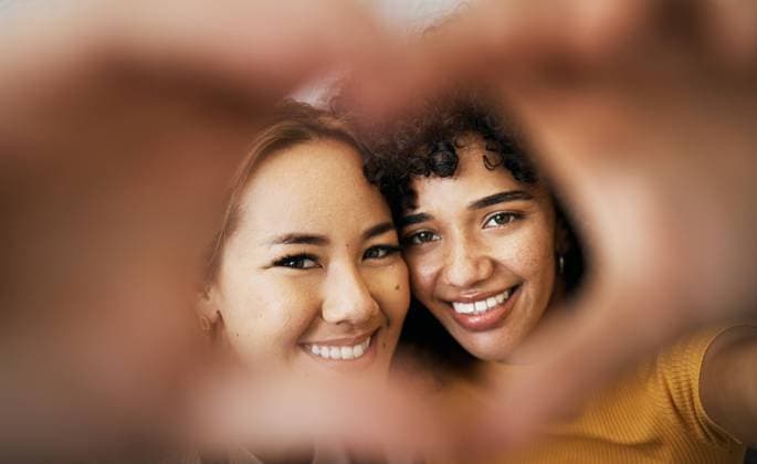 Lesbian couple, smile and heart with hands, portrait and closeup for romance, bonding and love and support for relationship. Happy people, together and solidarity for pride, lgbtq and hope for peace. model released property released Copyright: xwww.peopleimages.comx