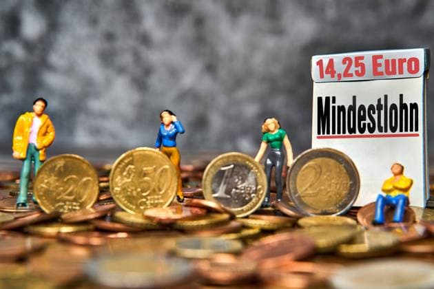 Bavaria, Germany - November 13, 2024: Minimum wage is written on a sign, symbolizing the increase in the minimum wage from 13.50 euros per hour to 14.25 euros per hour for employees from January 2025 in Germany. PHOTOMONTAGE *** Mindestlohn steht auf einem Schild, Symbol für Erhöhung des Mindestlohns von 13,50 Euro Stundenlohn auf 14,25 Euro Lohn für Arbeitnehmer pro Stunde ab Januar 2025 in Deutschland.