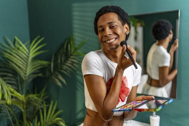 Porträt einer lateinamerikanischen glücklichen Transgender Person, die sich im Badezimmer zu Hause schminkt Portrait of a latin happy transgender person applying makeup in the bathroom at home Copyright: imageBROKER UnaixHuizi ibxuhu11763884.jpg ,model released, Symbolfoto ,property released