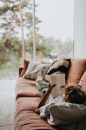IMAGO Creative, Winter, Couching Relaxed boy spending leisure time reading book while lying on sofa at home Sweden, Stockholm, model released, property released Copyright: xMaskotx , MA113039 MA113039