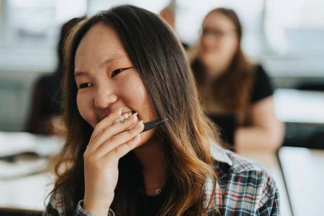 Happy female student with hand covering mouth at school Sweden, Gothenburg, model released, property released Copyright: xMaskotx , MA113302 MA113302