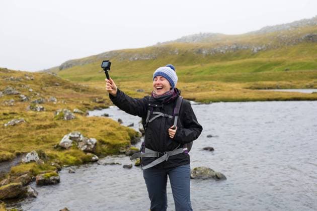 MR_ID24370_18630_ClaudiaAyusoRamirez.jpg, MR_ID24370_18631_MarcGarciaPinto.jpg Smiling young female influencer live streaming with an action camera on a foggy mountain for social media Solo travel in natural outdoors destination Model Released ClaudiaAyuso_ID24370_707035_057 Copyright: xClaudiaxAyusox