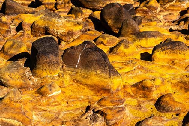 Creative Highlights World This striking image showcases a cluster of vibrant, yellow-tinted sulfur rocks Each stone is distinct, featuring rich textures and hues resulting from sulfuric deposits Model Released JuanLopez_ID24771_718001_013 Copyright: xJuanxLopezx
