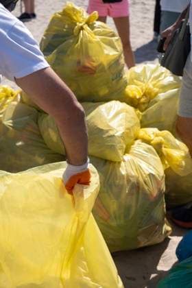 MR_ID24624_18718_IzanQuilezMoreno.jpg, MR_ID24624_18719_MartinaQuilezMoreno.jpg A close-up of volunteers gathering litter in yellow plastic bags to clean a sandy beach, promoting environmental conservation and marine protection Model Released PepeQuilez_ID24624_713618_018 Copyright: xPepexQuilezx RECORD DATE NOT STATED