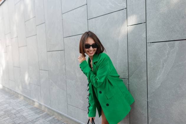 IMAGO Creative, Lifestyle, Frühling in der Stadt Happy schöne urbane Mode Frau lächelnd mit Vintage-Sonnenbrille in grünen Blazer stehend in der Nähe von grauen Wand in der Stadt *** Happy Beauty urban Fashion Woman smiling with Vintage Sunglasses in Greens Blazer standing in the Proximity from grey Wall in the City 1102820571 ,model released, Symbolfoto