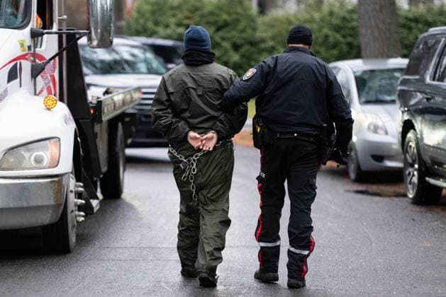 November 21, 2024, Ottawa, On, Canada: A Greenpeace climate activist (name not provided) is escorted to an Ottawa Police Service cruiser by an officer after being arrested for taking part in a sit-in styled protest calling for greater climate change awareness by Conservative Leader Pierre Poilievre, outside of Stornoway, the official residence of the country s official opposition, in Ottawa, on Thursday, Nov. 21, 2024. Ottawa Canada  - ZUMAc35_ 20241121_zaf_c35_009 Copyright: xSpencerxColbyx