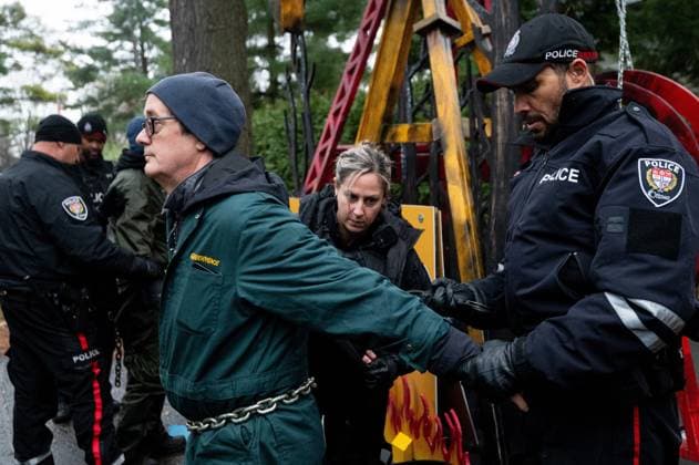 November 21, 2024, Ottawa, On, Canada: Greenpeace climate activist Keith Stewart, left, is handcuffed by Ottawa Police Service officers after being arrested by the OPS for taking part in a sit-in styled protest calling for greater climate change awareness by Conservative Leader Pierre Poilievre, outside of Stornoway, the official residence of the country s official opposition, in Ottawa, on Thursday, Nov. 21, 2024. Ottawa Canada  - ZUMAc35_ 20241121_zaf_c35_010 Copyright: xSpencerxColbyx