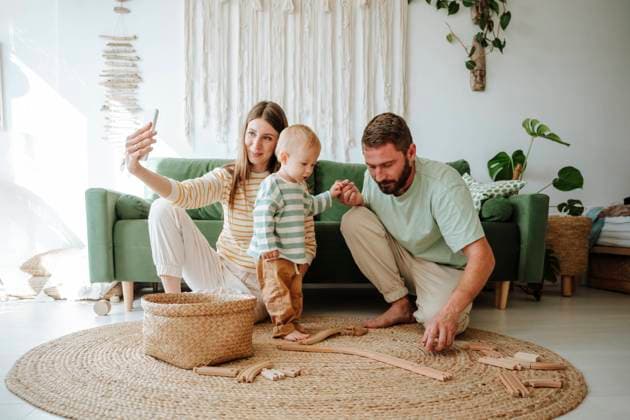 Mother taking selfie with her family in living room at home model released, Symbolfoto property released, WESTF25307