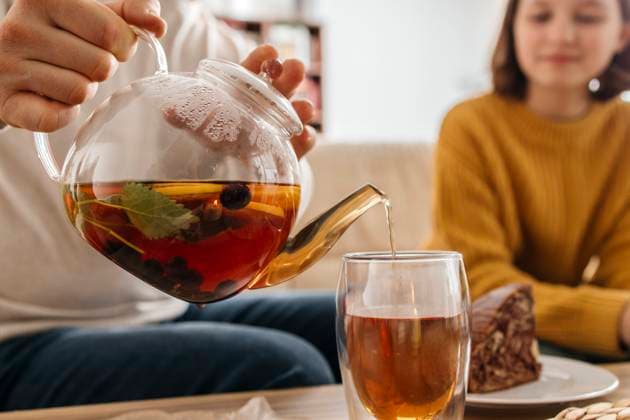 Man pouring tea in glass near daughter at home model released, Symbolfoto property released, ELMF01062