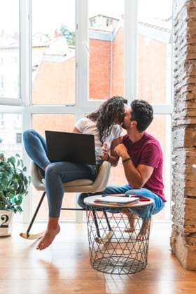 Woman with laptop kissing man at home model released, Symbolfoto property released, JAQF01734