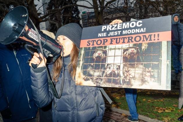 News Themen der Woche KW47 News Bilder des Tages Fur Free Day 2024, an animal rights protest against fur farms. Animal rights activist with megaphone and photo of animals from fur farm with caption: violence is not fashionable! stop fur! Warsaw Poland Copyright: xMikolajxJaneczekx