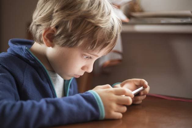 Creative Highlights Symbolbilder Junger niedlicher Junge, der aus kurzer Entfernung auf sein Smartphone schaut Young cute boy looking aat smartphone from short distance. Copyright: imageBROKER PiotrxDziurman ibxpdz11818943.jpg ,model released, Symbolfoto ,property released