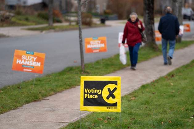November 26, 2024, Halifax, Ns, Canada: A sign directing voters in the Nova Scotia provincial election is seen as pedestrians walk past in Halifax, Tuesday, Nov. 26, 2024. Halifax Canada  - ZUMAc35_ 20241126_zaf_c35_026 Copyright: xDarrenxCalabresex