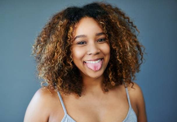 Creative Highlights Symbolbilder Happy, tongue out or African woman with hair care, portrait or natural afro for beauty or cosmetics. Gray background, funny face or confident model in studio with growth, texture or joke in Somalia. model released property released Copyright: xwww.PeopleImages.com-licencexrestrictionsxapplyx
