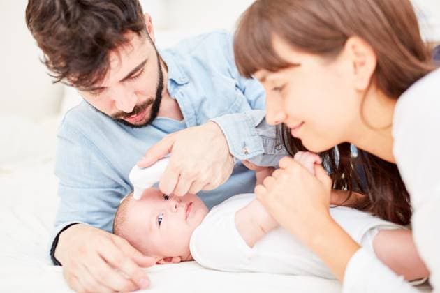 Eltern messen Temperatur bei ihrem Baby mit dem Infrarot Stirnthermometer ,model released, Symbolfoto ,property released  Copyright: xZoonar.com RobertxKneschkex 11792797 ,model released, Symbolfoto ,property released
