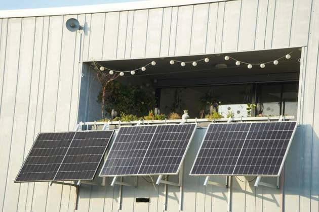 Ein grosses Balkonkraftwerk vor einem begrünten Balkon, 4 solar modules are installed at an angle in front of a balcony built into the facade. The modules are illuminated by the sun and are currently producing a lot of electricity. The balcony is full of plants., 4 solar modules are installed at an angle in front of a balcony built into the facade. The modules are illuminated by the sun and are currently producing a lot of electricity. The balcony is full of plants., 13.11.2024, Copyright: xGrafikdienstx Panthermedia38290255.jpg